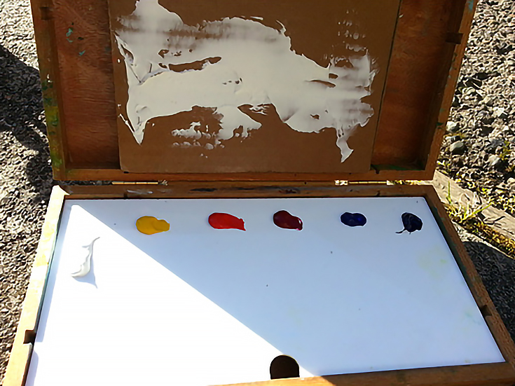 Open pochade box with paint laid out on palette