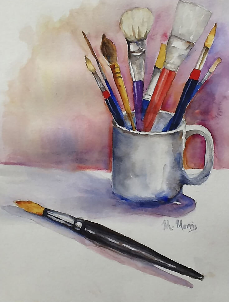Several watercolor brushes in an old cup