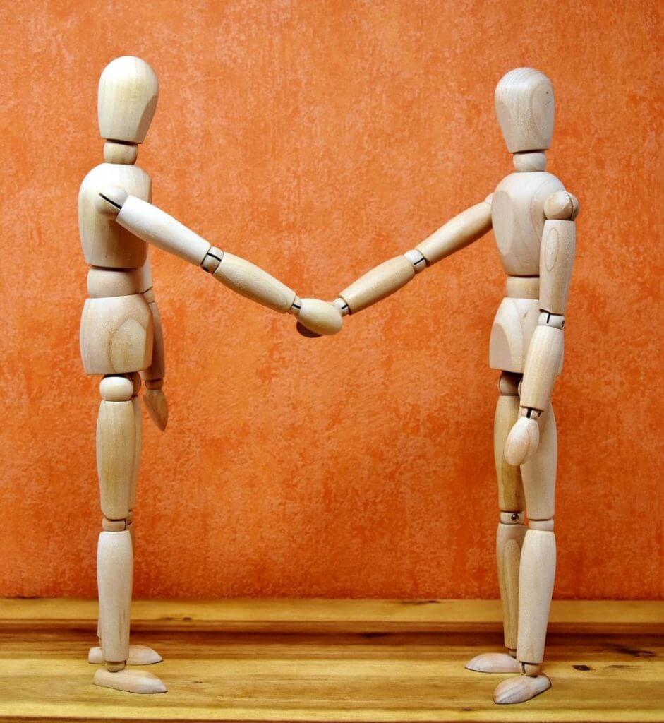 Two drawing manikins shaking hands