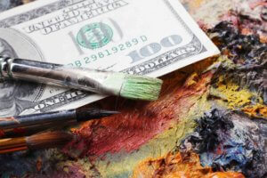 hundred dollar bill among painting materials