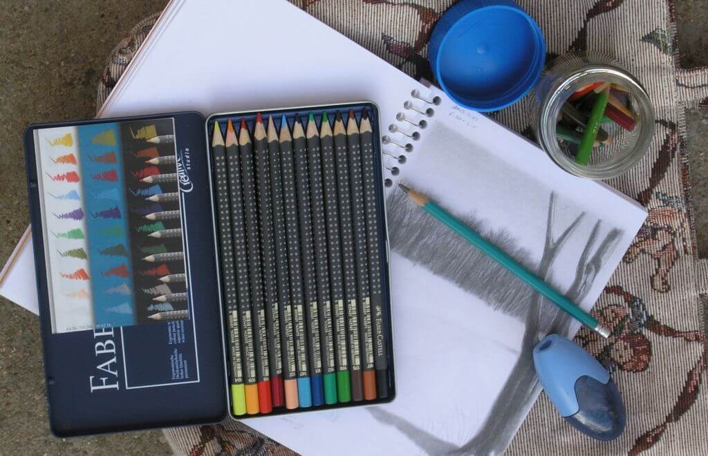 And artist field kit - colored pencils, sketchpad and graphite pencil.