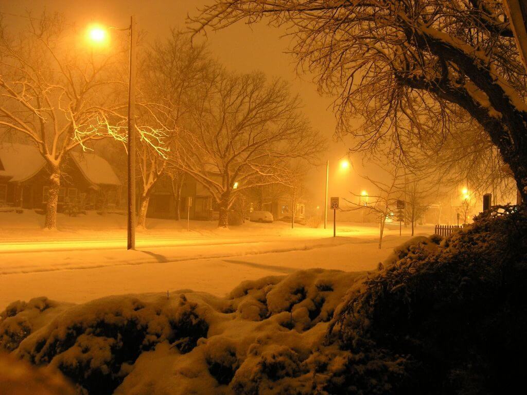 Glowing street lamps on a snowy winter street
