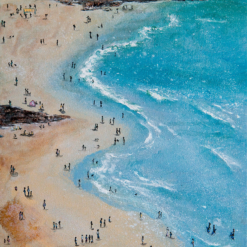 A view of a sandy, curved coastline (with lots of beachgoers) from high up